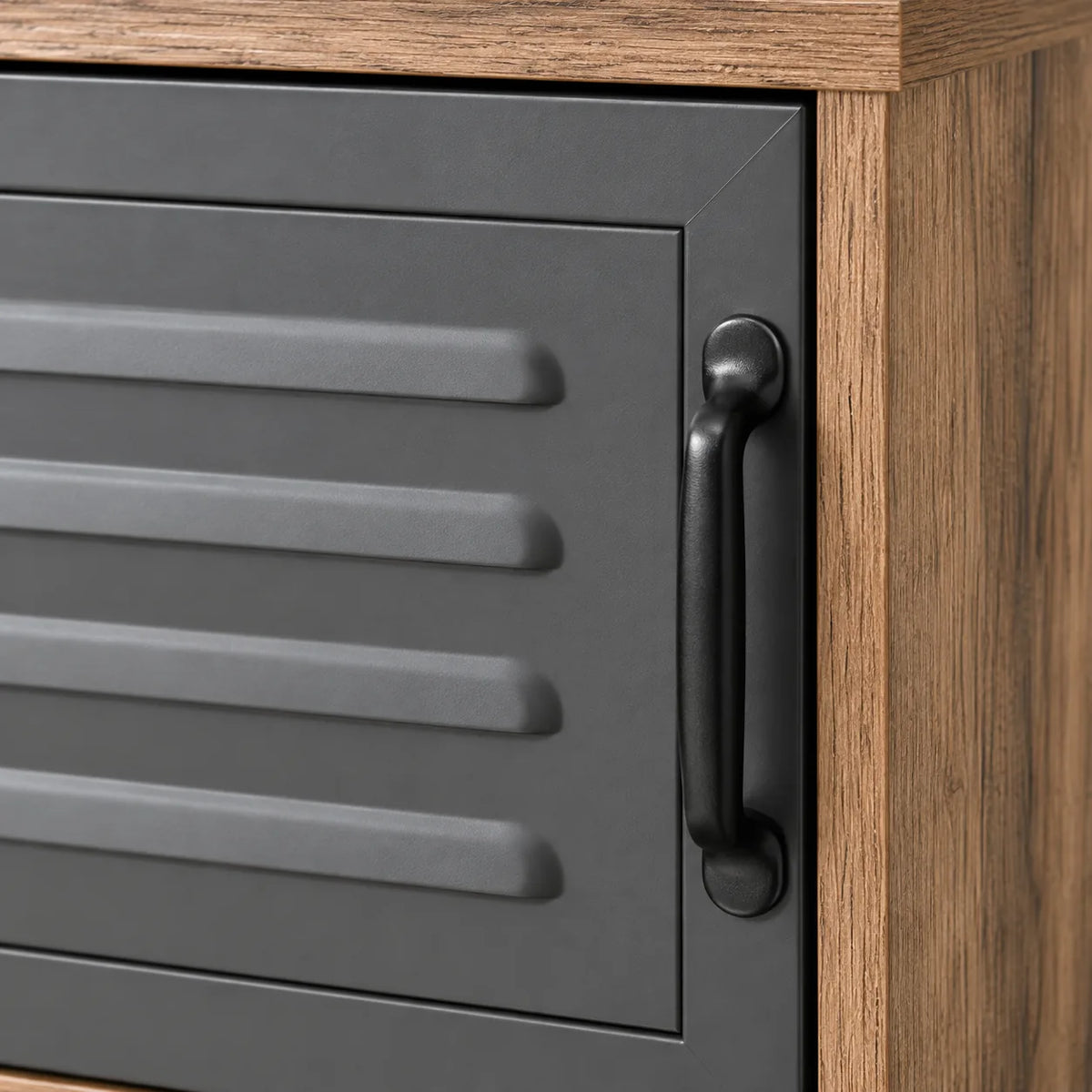 Détail de la porte métallique ventilée et de la poignée noire du meuble TV Elvar