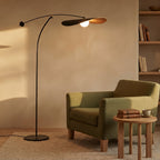 Lampadaire Kaiven noir positionné au-dessus d’un canapé dans un salon