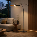 Lampadaire Kaiven noir éclairant un fauteuil dans un coin lecture